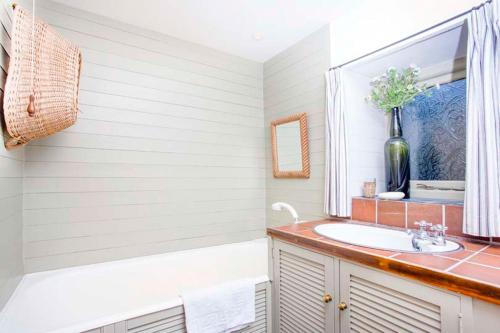 a bathroom with a sink and a mirror at Girl Annie, Cornish Cottage With Superb Sea Views & Garden, By Beach in Sennen