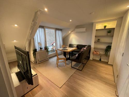 a living room with a table and a television at TopSleep Apartments 24-3 in Arnhem