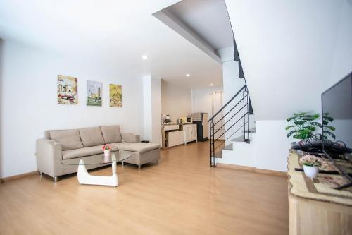 a living room with a couch and a table at Bangsean Smile Home บ้านสไมล์ บางแสน in Bangsaen