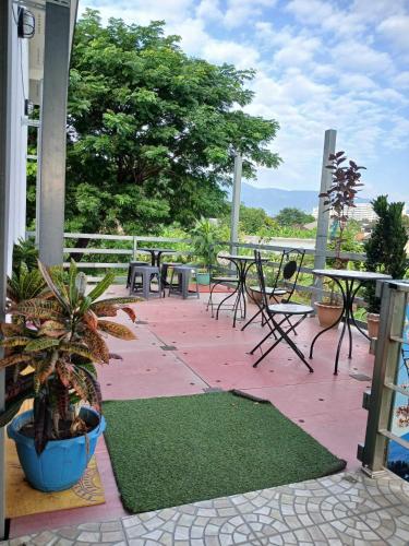 un patio con mesas y sillas y una maceta en Sakura House, en Chiang Mai