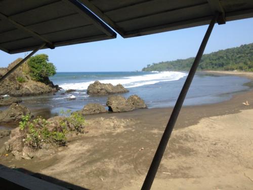 a view of a beach with rocks and the ocean at The Hill B&B (El Morro Hosteria) in El Valle
