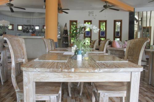 a wooden table and chairs in a restaurant at Luz_ita Sunshine Villa in Uluwatu