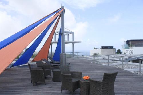 a wooden boardwalk with chairs and a blue and orange flag at Luz_ita Sunshine Villa in Uluwatu