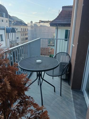 a table and two chairs on a balcony at Apartaments and Rooms Claudia Augusta in Bolzano