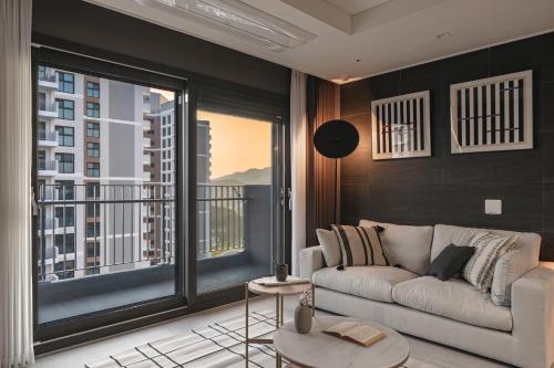 a living room with a couch and a large window at Le Collective Busan Gijang in Busan