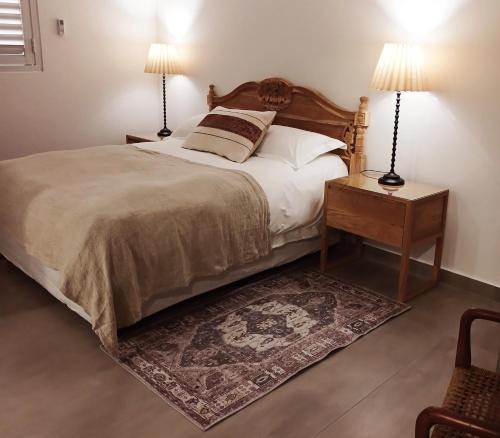 a bedroom with a bed with two lamps and a rug at 10 Jock Meiring in Bloemfontein