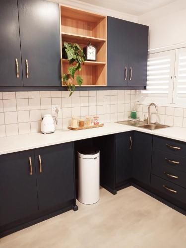 a kitchen with black cabinets and a sink at 10 Jock Meiring in Bloemfontein