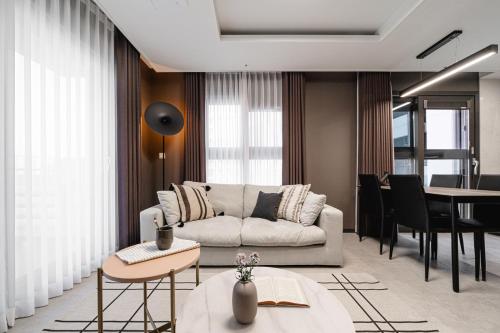a living room with a couch and a table at Le Collective Busan Gijang in Busan