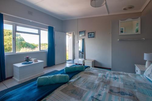 a bedroom with a large bed and a window at À La Mer - Selfcatering Unit in Agulhas