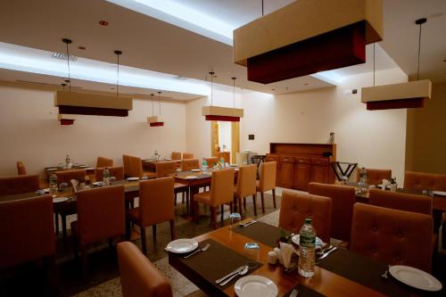 a dining room with tables and chairs and a piano at Beeza Clubhouse in Kottayam