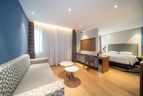 a hotel room with a bed and a desk at Holiday Inn Express Shanghai Pujiang Lianhang Road by IHG in Shanghai