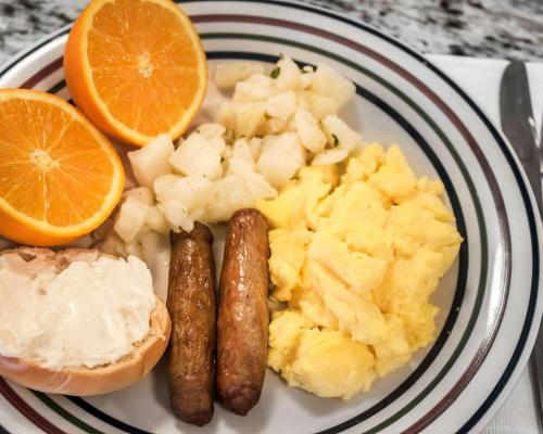 a plate of breakfast food with sausage and orange slices at Quality Inn in Pocatello