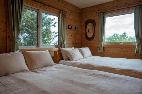 due letti in una stanza con due finestre di Best View a Nakafurano