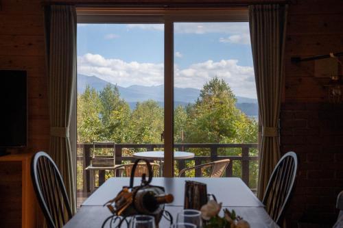 a dining room with a table and a large window at Best View in Nakafurano
