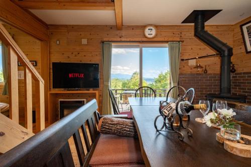 un soggiorno con tavolo e camino di Best View a Nakafurano