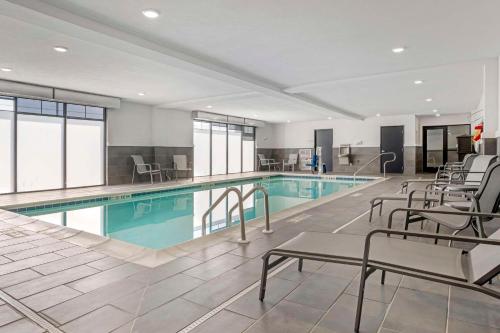 a pool in a hotel with chairs and a swimming pool at Comfort Inn & Suites Clarksville - Louisville North in Clarksville