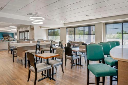 a waiting room with tables and chairs and windows at Comfort Inn & Suites Clarksville - Louisville North in Clarksville