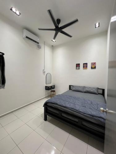 a bedroom with a bed and a ceiling fan at Meera Homestay in Malacca