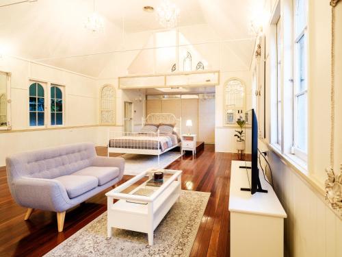 a living room with a couch and a bed at Little White Chapel Maleny in Maleny