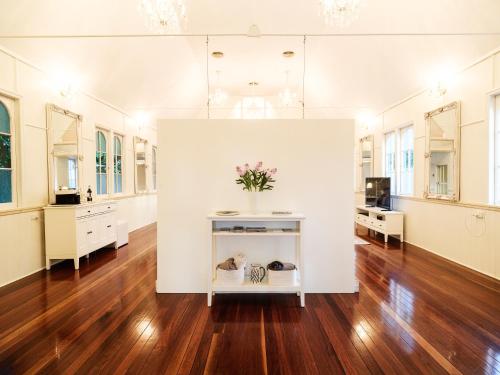 a large room with wooden floors and white walls at Little White Chapel Maleny in Maleny