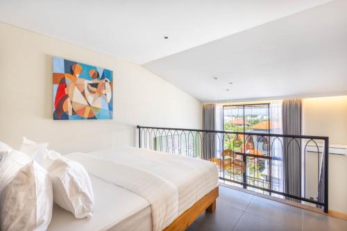 een slaapkamer met een bed en een balkon bij Santos Suites in Badung