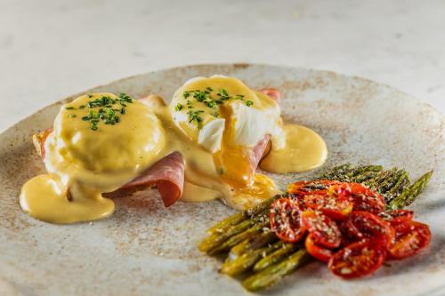 a plate of food with meat and eggs and asparagus at The Residence Aiolou Hotel & Spa in Athens