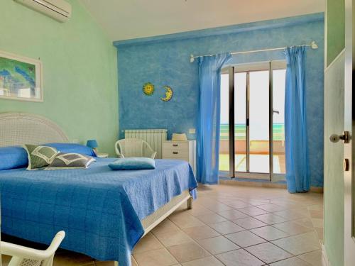 a bedroom with a bed with blue walls and a window at Casa MaTu in Nettuno