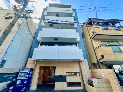 a tall building with balconies on a city street at Rest Collection Bentencho Osaka in Osaka