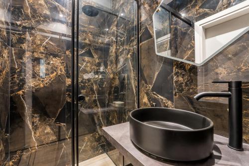 a bathroom with a black sink and a shower at Alma Suite - close to Acropolis in Athens