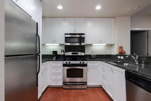 a kitchen with white cabinets and stainless steel appliances at Blueground Santa Clara 2bd apartment SFO-1771 in Milpitas