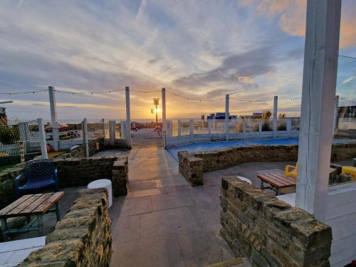 a patio with benches and a sunset in the background at Seaside Holiday Home Inside a Resort in Selsey