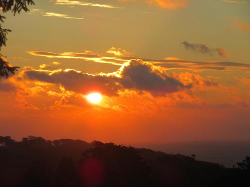 a sunset over the ocean with clouds in the sky at Evening Star Cottages in Saundersfoot