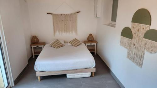 a small bedroom with a bed and two tables at Chambres Domaine de Saint Marc in Saint-Médard