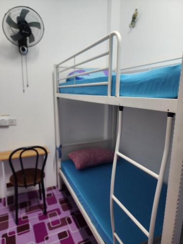 a room with two bunk beds and a chair at Homestay Zaishazali in Gelugor