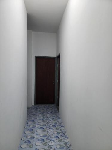 an empty hallway with a door and a tile floor at Homestay Zaishazali in Gelugor