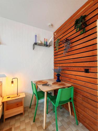 - une table et des chaises dans une chambre dotée d'un mur en bois dans l'établissement Veronese, à Annecy