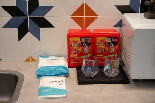 a kitchen counter with two boxes of food and two cups at Suyi Hotel Apartment in Sha-ho-p'u