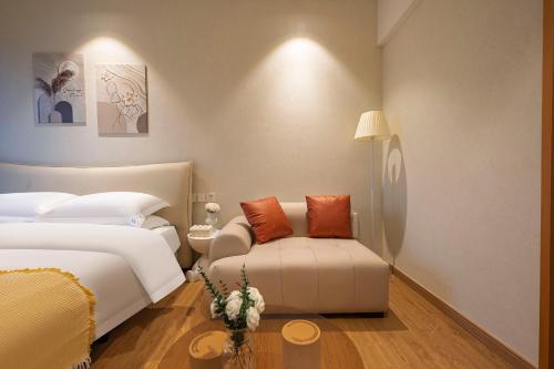 a hotel room with two beds and a couch at Suyi Hotel Apartment in Sha-ho-p'u