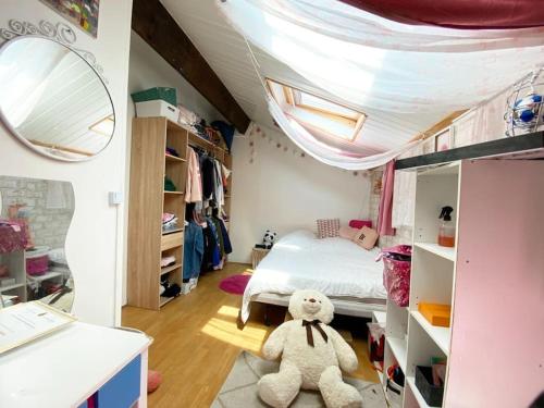- une chambre avec un lit et un ours en peluche au sol dans l'établissement Agréable Duplex de type F4, à Sevran