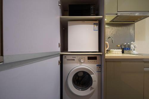 a kitchen with a washing machine in a kitchen at Suyi Hotel Apartment in Sha-ho-p'u