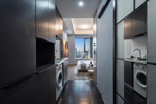 a kitchen with a washer and dryer in a house at Suyi Hotel Apartment in Sha-ho-p'u