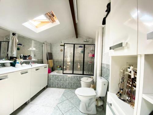 une salle de bain avec toilettes, lavabo et baignoire dans l'établissement Agréable Duplex de type F4, à Sevran