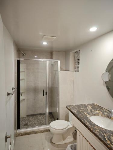 a bathroom with a shower and a toilet and a sink at Chamber Inn in Edmonton
