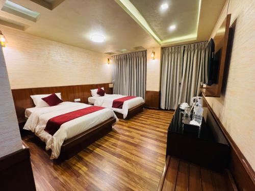 a hotel room with two beds and a television at Hotel Nova Nook Pvt Ltd in Kathmandu