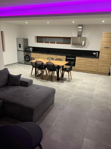 - un salon avec un canapé, une table et un piano dans l'établissement Appartement Le Belarya, à Wintzenheim