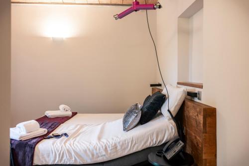 a room with a bed with a light on the wall at Abbatissa Hotel Restaurant in Sant Joan de les Abadesses