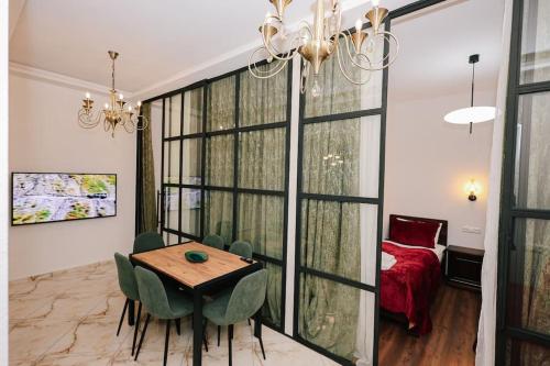 トビリシにあるCondo in the old Tbilisi - on Mtawmindaのテーブルと緑の椅子のあるダイニングルーム