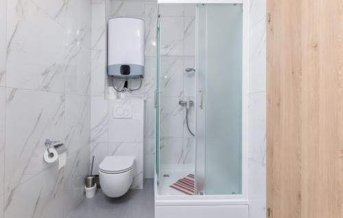 a white bathroom with a shower and a toilet at Ferienhaus Anton in Peroj