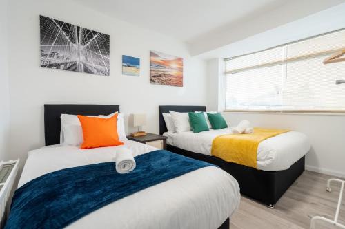 a bedroom with two beds and a window at Ace Place - Pool Table - Etihad - Opposite Train Station in Moston
