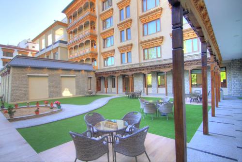 an outdoor patio with chairs and a lawn in front of a building at The Abduz in Leh